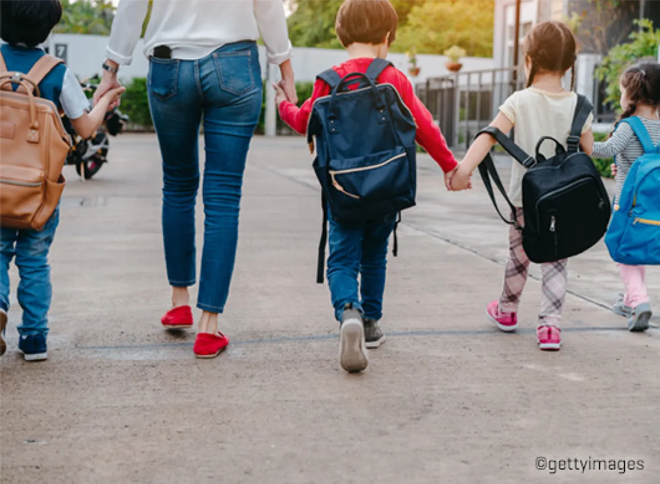 Kinderen die hand in hand lopen met een volwassene